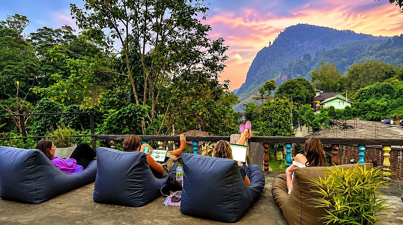 
            Guests watching the sunset from the terrace
            at Rock View Hostel Ella, with Ella Rock
            in the background
          